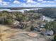 An aerial view of houses on a golf course with lake access and mature trees under a blue sky with some clouds at 1019 Palmyra Dr, Fort Mill, SC 29708