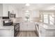 Bright, newly renovated kitchen with white cabinets, stainless steel appliances and light-colored counters at 10718 Downpatrick Pl, Charlotte, NC 28262