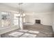 Bright, open living room featuring light gray floors, neutral walls, and a brick fireplace at 10718 Downpatrick Pl, Charlotte, NC 28262