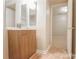 Bathroom with a vanity with cabinet storage and a view to another room through an open door at 10946 Garden Oaks Ln, Charlotte, NC 28273