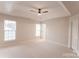 Spacious bedroom with a ceiling fan and two windows providing ample natural light at 10946 Garden Oaks Ln, Charlotte, NC 28273