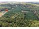 An aerial view of lush, wooded acreage along Mt Holly-Huntersville Rd with a private pond at 11001 Mount Holly Hntrsvlle Rd, Huntersville, NC 28078