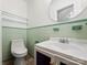 Small bathroom with mint green tile and updated vanity at 115 E Texas Ave, Bessemer City, NC 28016