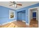 Bedroom with hardwood floors, blue walls, and ceiling fan at 115 E Texas Ave, Bessemer City, NC 28016