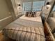 Bedroom with queen bed, patterned bedding, and built-in shelving at 130 Badin Lake Cir, New London, NC 28127