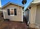 Tan mobile home with attached shed and satellite at 130 Badin Lake Cir, New London, NC 28127