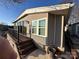 Tan mobile home with deck and steps leading to the ground at 130 Badin Lake Cir, New London, NC 28127