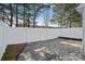 Paver backyard features white vinyl fence and tall pines for private outdoor enjoyment at 141 N Arcadian Way, Mooresville, NC 28117