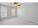 Bright, carpeted bedroom with two large windows and a ceiling fan at 141 N Arcadian Way, Mooresville, NC 28117