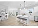 Open-concept kitchen with island seating, pendant lights, and white cabinetry, connected to the dining area at 14309 King Eider Dr, Charlotte, NC 28273