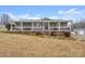 Gray mobile home with wrap-around porch, steps, and American flag at 15918 Big Bear Rd, Albemarle, NC 28001