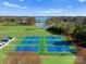 Aerial view of blue tennis courts near a beautiful lake and well-manicured landscaping at 162 Wild Harbor Rd, Mooresville, NC 28117