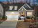 Two-story house with stone and white accents, two car garage, and landscaping at 16400 Cozy Cove Rd, Charlotte, NC 28278