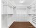 Spacious walk-in closet, built-in shelves, and hanging rods at 16400 Cozy Cove Rd, Charlotte, NC 28278