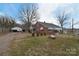 Brick home with large front yard, mature trees, detached garage, and covered parking area at 1648 Newton Dr, Statesville, NC 28677