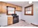 Kitchen area featuring wood cabinets, laminate flooring, black range, and a window providing natural light at 1648 Newton Dr, Statesville, NC 28677