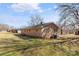 Rear exterior view of a brick home with a well-maintained yard and mature trees at 226 Bradley Farm Rd, Statesville, NC 28625