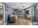 Cozy living room featuring hardwood floors, a gray sofa, ceiling fan, and modern entertainment center at 226 Bradley Farm Rd, Statesville, NC 28625