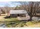 Aerial view of a single-story home with a metal roof, front porch and mature trees at 236 Ervin Rd, Mooresville, NC 28117