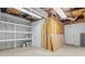 Unfinished basement with open ceiling, built-in shelving, and a door to the outside at 236 Ervin Rd, Mooresville, NC 28117