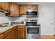 Kitchen area featuring stainless steel appliances, wood cabinets, and a convenient door to the hallway at 236 Ervin Rd, Mooresville, NC 28117