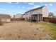 View of the home's backyard with a covered patio, shed, and wooden fence at 2415 Impatien Dr, Charlotte, NC 28215