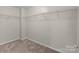 Walk in closet offers ample storage with shelving and neutral carpet at 2415 Impatien Dr, Charlotte, NC 28215