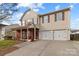 Charming two-story home with a welcoming front porch and a two-car attached garage at 2415 Impatien Dr, Charlotte, NC 28215