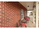 Inviting brick front porch with decorative seating and side table at 2415 Impatien Dr, Charlotte, NC 28215