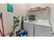 Functional laundry room with washer, dryer, and storage shelf at 2415 Impatien Dr, Charlotte, NC 28215