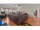 Cozy living room with a large sofa and wood look floors and good natural light at 2415 Impatien Dr, Charlotte, NC 28215