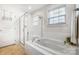 Bright bathroom features a soaking tub and a glass-enclosed shower with white tile at 2727 Cypress Oak Ln, Gastonia, NC 28056