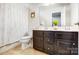 Well-lit bathroom with dual sinks, dark wood vanity, and a shower-tub combination at 2727 Cypress Oak Ln, Gastonia, NC 28056