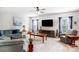 Bright living room featuring plush seating, a ceiling fan, and large windows with blue curtains at 2727 Cypress Oak Ln, Gastonia, NC 28056