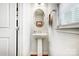 Small powder room with a pedestal sink, decorative mirror and picture, plus a window with natural light at 2727 Cypress Oak Ln, Gastonia, NC 28056