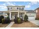 Charming two-story home features a welcoming front porch with classic columns and a two-car garage at 328 Sensibility Cir, Fort Mill, SC 29708