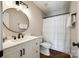 Bathroom with white vanity, black fixtures, round mirror and tub with shower at 3331 Center Rd, Chester, SC 29706