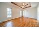 A light-filled bedroom boasts hardwood floors, a decorative tray ceiling, and two windows for ample natural light at 3447 Nesting Ln, Fort Mill, SC 29708