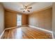 A cozy bedroom with patterned wallpaper, hardwood floors, a ceiling fan, and a window with natural light at 3447 Nesting Ln, Fort Mill, SC 29708