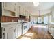 This kitchen boasts white appliances and wood floors, next to a large window-filled eating area at 3447 Nesting Ln, Fort Mill, SC 29708