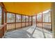 View of screened porch with yellow ceiling, wood railing, for a relaxing outdoor space and view of yard at 3447 Nesting Ln, Fort Mill, SC 29708