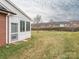 Backyard view with a covered porch, a brick wall and open yard area at 3867 Azalea Trl, Denver, NC 28037