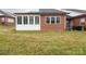 Spacious backyard with a green lawn, brick exterior, and a screened-in sunroom addition at 3867 Azalea Trl, Denver, NC 28037