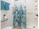 Detailed view of the bathroom shower with grab bars and curtain with blue flower design at 3867 Azalea Trl, Denver, NC 28037