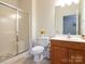 Well-lit bathroom with a glass-enclosed shower, tile flooring, and a wood vanity at 3867 Azalea Trl, Denver, NC 28037