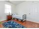 Bedroom featuring wood floors, a small bed with blue rug, dresser, and a lamp at 3867 Azalea Trl, Denver, NC 28037