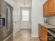 Kitchen features stainless steel refrigerator, tile floor, shaker cabinets, and natural light from the window at 3867 Azalea Trl, Denver, NC 28037