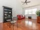 Living room featuring a red sofa and a glass table, ceiling fan and hardwood floors at 3867 Azalea Trl, Denver, NC 28037