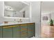 Stylish bathroom features a green vanity with gold fixtures and an illuminated mirror, adding a modern touch at 3995 Burton Ln, Denver, NC 28037