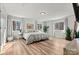 Spacious bedroom featuring wood flooring, a large bed, and natural light from multiple windows at 3995 Burton Ln, Denver, NC 28037